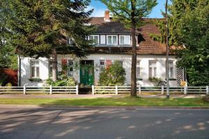 a white house with a white fence in front of it at Die Kleine Ferienwohnung in Schneverdingen