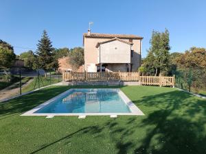 a swimming pool in a yard with a house at Cal Trumfet in Caserras