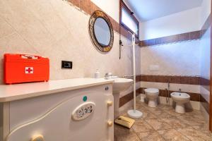 a bathroom with a sink and a toilet and a mirror at Casa Vacanze vicino ad alghero in Olmedo +16 photos