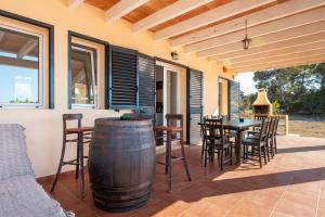 a patio with a table and chairs and a barrel at Es Camp in Cala Saona