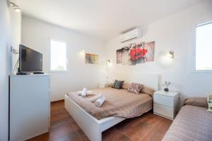 a bedroom with a bed and a flat screen tv at Es Camp in Cala Saona