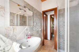 a bathroom with a white sink and a shower at Villa Is Sorrisi in Gonnesa