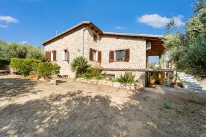 a large stone house with a yard in front of it at Villa Is Sorrisi in Gonnesa
