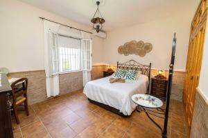a bedroom with a bed and a table and a window at Villa mis Raices in Castilblanco de los Arroyos +32 photos