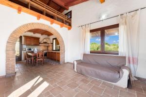 a living room with a couch and a kitchen at Villa Is Sorrisi in Gonnesa