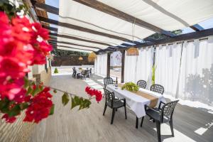 a patio with a table and chairs and red flowers at Villa mis Raices in Castilblanco de los Arroyos
