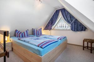 a bedroom with a bed with blue sheets and a window at Haus Arvert in Koserow