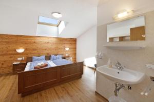 a bedroom with a bed with a sink and a mirror at Alpenchalet Lacknerbrunn bis 30 P in Mayrhofen