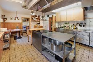 a large kitchen with stainless steel appliances and a table at Alpenchalet Lacknerbrunn bis 30 P in Mayrhofen +34 photos