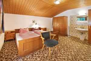 a bathroom with a bed and a chair and a sink at Alpenchalet Lacknerbrunn bis 30 P in Mayrhofen