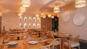 a restaurant with wooden tables and chairs and chandeliers at Athena Premium Suites in Erdemli