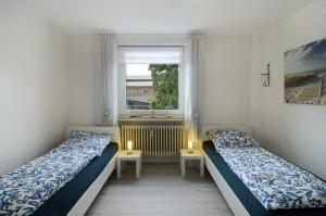 two beds in a small room with a window at Ferienwohnung Storchenblick in Grebendorf