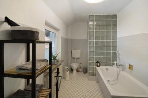 a bathroom with a tub and a toilet and a sink at Ferienwohnung Storchenblick in Grebendorf +45 photos
