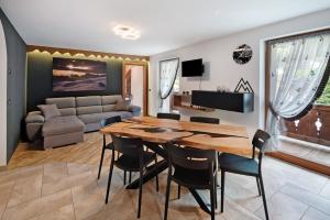 a dining room and living room with a table and chairs at Ciasa Badia in Pozza di Fassa