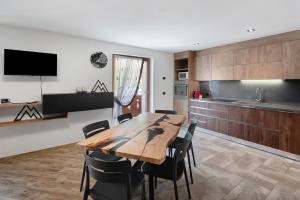 a kitchen and dining room with a wooden table and chairs at Ciasa Badia in Pozza di Fassa