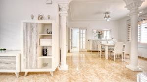 a white dining room with a table and chairs at Costacabana - Villa Sarai in Lloret de Mar