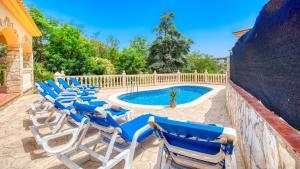 a row of lounge chairs next to a swimming pool at Costacabana - Villa Sarai in Lloret de Mar