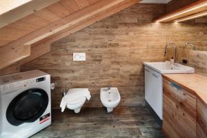 a bathroom with a washing machine and a sink at Ciasa Badia in Pozza di Fassa +25 photos