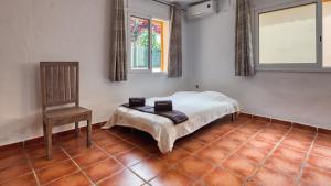 a bedroom with a bed and a chair in it at Costacabana - Villa Sarai in Lloret de Mar