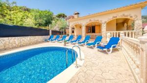 a villa with a swimming pool and chairs at Costacabana - Villa Sarai in Lloret de Mar