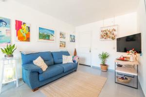 a living room with a blue couch and a tv at Taiko in Port de Pollensa