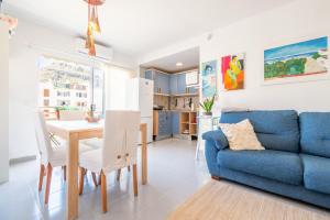 a living room with a blue couch and a table and chairs at Taiko in Port de Pollensa