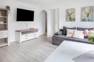 a living room with a couch and a tv at Ferienwohnung Holly in Ebringen