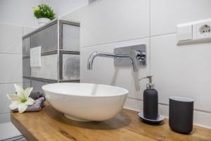 a bathroom with a white bowl sink on a wooden counter at Ferienwohnung Holly in Ebringen +12 photos