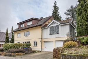 a white house with a garage at Ferienwohnung Holly in Ebringen