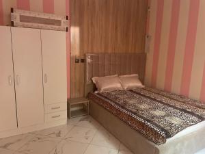 a small bedroom with a bed and a cabinet at AMAZIGH BIG Family APARTMENT in Meknès