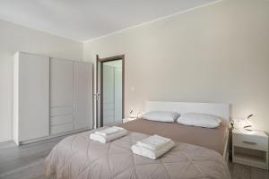a white bedroom with two white towels on a bed at Casa Sparto in Meganisi