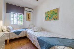 a small room with two beds and a window at La Ponderosa 5 in Mijas Costa