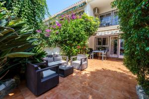 a patio with furniture and plants and a building at La Ponderosa 5 in Mijas Costa