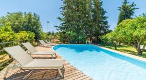 a swimming pool with two chairs and a poolvisorvisor at Sa Teulera de Sencelles in Sencelles