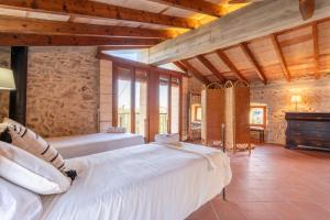 a bedroom with two beds in a room with wooden ceilings at Sa Teulera de Sencelles in Sencelles +35 photos