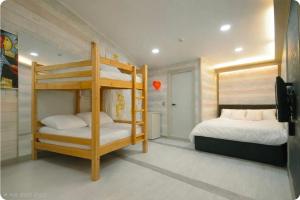 a bedroom with two bunk beds and a tv at Family Hotel BNB in Busan +80 photos