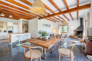 a kitchen and living room with a wooden table and chairs at Sa Teulera de Sencelles in Sencelles