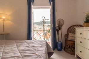 a bedroom with a bed and a large window at Beach And Mountain Apartment in Sesimbra