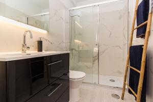 a bathroom with a shower and a sink and a toilet at Beach And Mountain Apartment in Sesimbra +23 photos