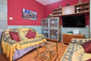 a living room with a couch and a flat screen tv at Pisos Leopoldo - Casaio in Casayo