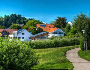 a path through a village with houses and trees at Alpenblick 1 in Lindau-Bodolz