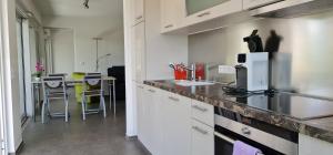 a kitchen with white cabinets and a table with chairs at Alpenblick 1 in Lindau-Bodolz +7 photos