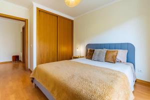 a bedroom with a large bed with a blue headboard at Casa Sol in Caniço +11 photos
