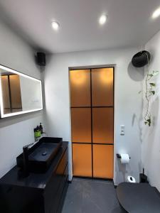 a bathroom with a sink and a wooden door at Design Apartment in Vesterbro with Large Balcony in Copenhagen +39 photos