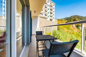 a balcony with two chairs and a table at Casa Sol in Caniço