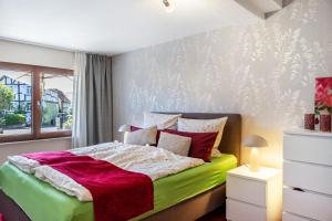 a bedroom with a green and white bed and a window at Ferienwohnung Efzeglück mit Pool in Homberg
