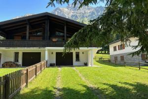 a house with a fence and a grass yard at Chalet Soleada with Fireplace and Terrace for 5 - Happy Rentals in Pian San Giacomo