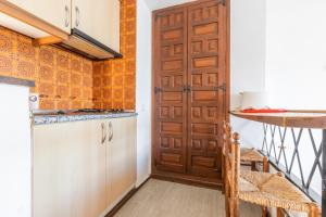 a kitchen with a wooden door and a counter at Calpe primera linea con piscina in Casas de Torrat