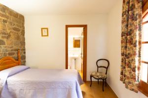 a bedroom with a bed and a chair and a window at Ca la Irene I in Begur