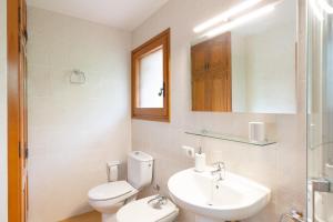 a bathroom with a toilet and a sink and a mirror at Ca la Irene I in Begur +13 photos